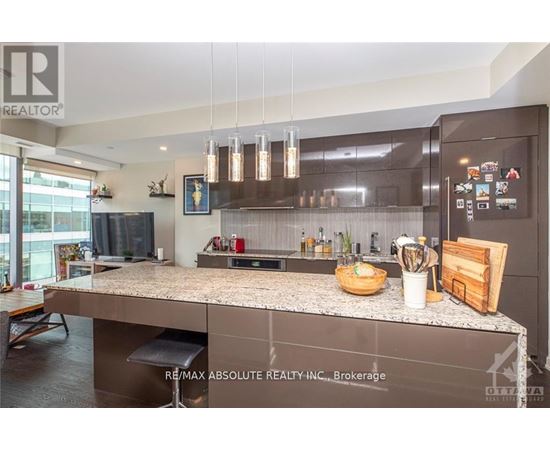 A modern kitchen with a large island and stainless steel appliances.