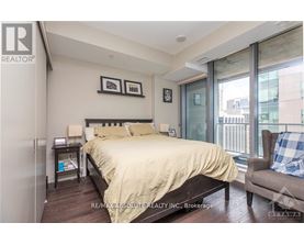 A bedroom with a bed, chair, and window.