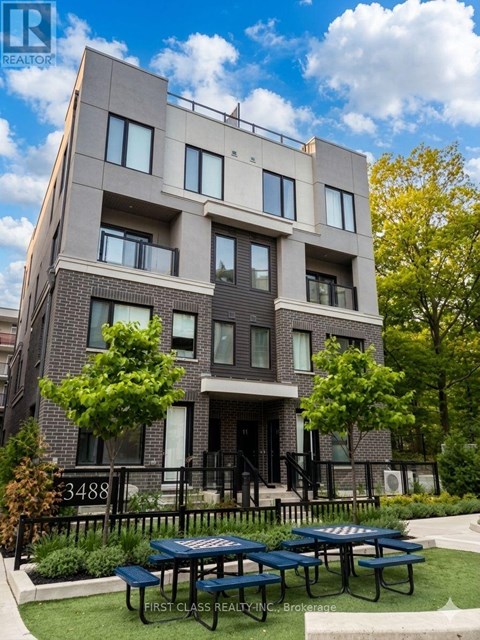 A modern apartment building with a green lawn in front.