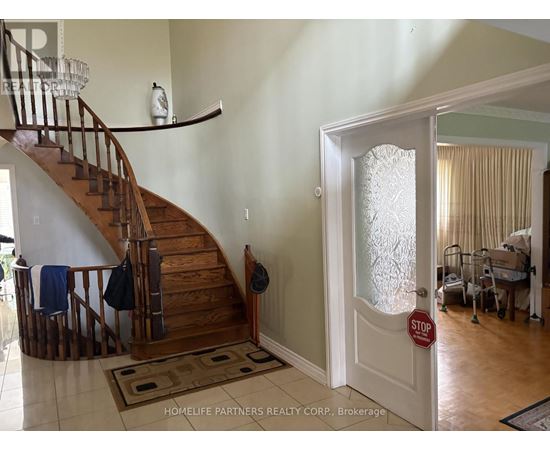 A hallway with a staircase and a door with a stop sign on it.