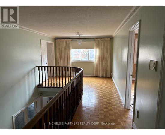A room with a window and a wooden floor.