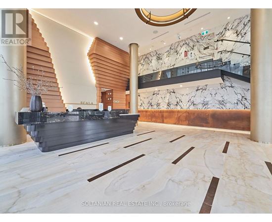 A marble staircase with a wooden handrail and a sign that says "Scala".
