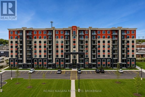 A multi-story building with a parking lot in front.