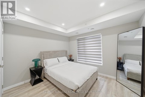 A bedroom with a large bed and a mirror on the wall.
