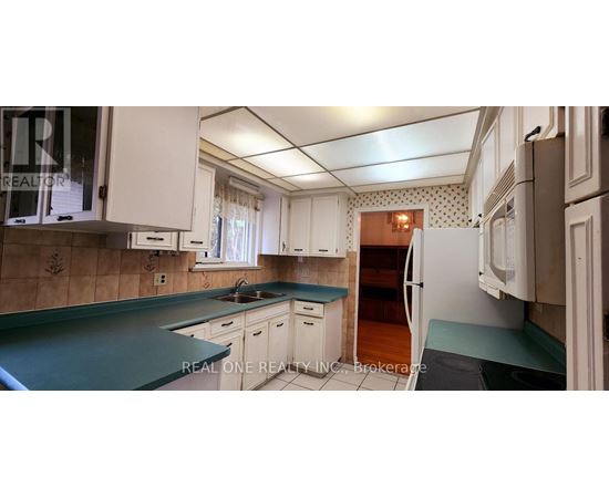 A kitchen with white cabinets and a green countertop.