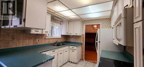 A kitchen with white cabinets and a green countertop.