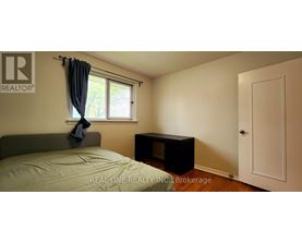 A bedroom with a bed, window, and a door.