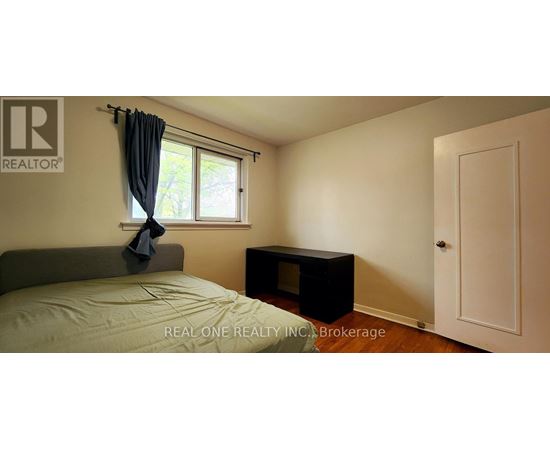 A bedroom with a bed, window, and a door.