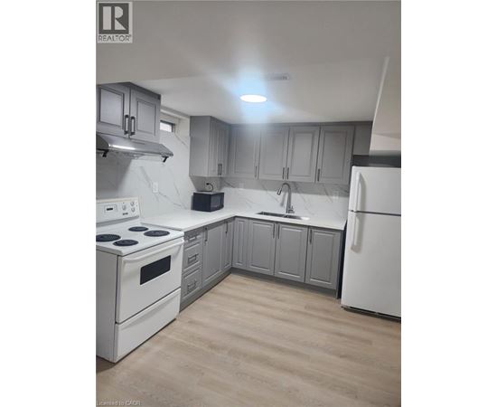 A kitchen with white appliances and grey cabinets.