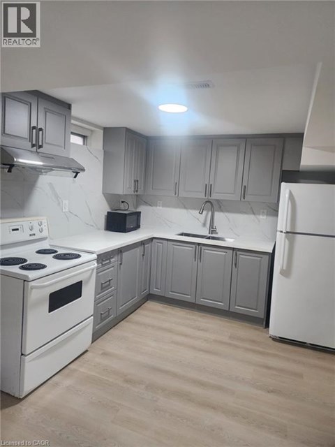 A kitchen with white appliances and grey cabinets.