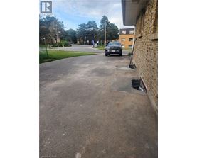 A black car is parked on a driveway.