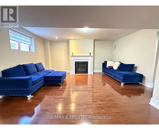 A living room with a blue couch and a fireplace.