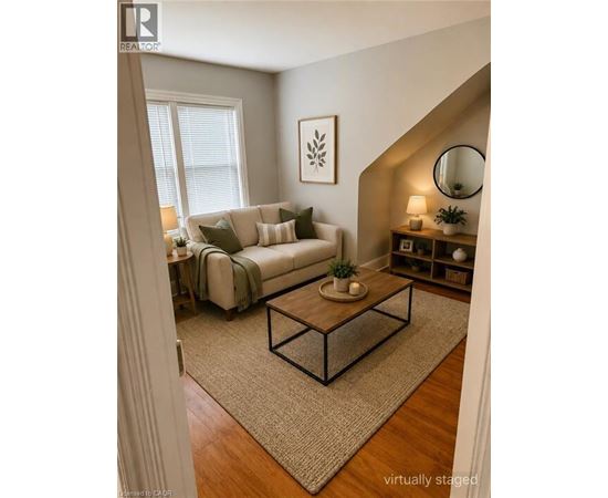 A living room with a couch, a coffee table, and a mirror.