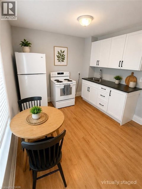 A kitchen with a table and chairs in front of a refrigerator and oven.