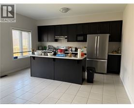 A kitchen with black cabinets and a white refrigerator.