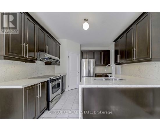 A kitchen with dark brown cabinets and stainless steel appliances.
