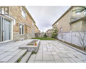 A stone walkway leads to a small garden in the middle of a residential area.