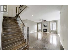 A spacious living room with a staircase leading to the upper floor.