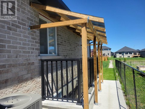 A wooden pergola attached to a brick building with a sign that says REALTOR.