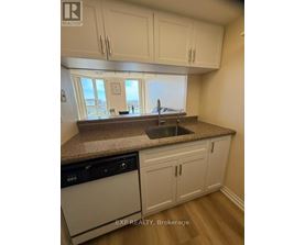 A kitchen with white cabinets and a granite countertop.