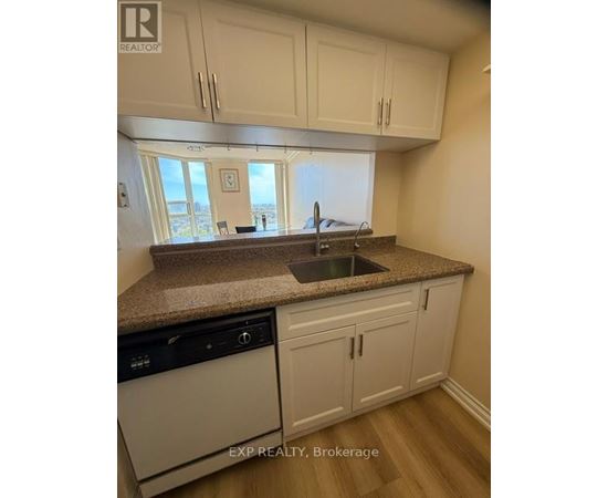 A kitchen with white cabinets and a granite countertop.