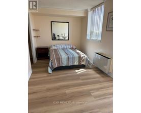A bedroom with a bed, a mirror, and a window.