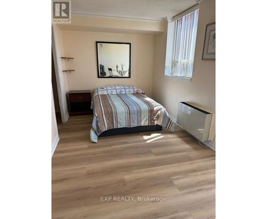 A bedroom with a bed, a mirror, and a window.