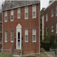 A red brick building with a white door and windows.
