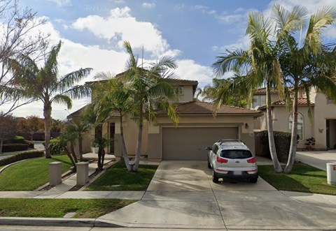 A house with a car parked in front.