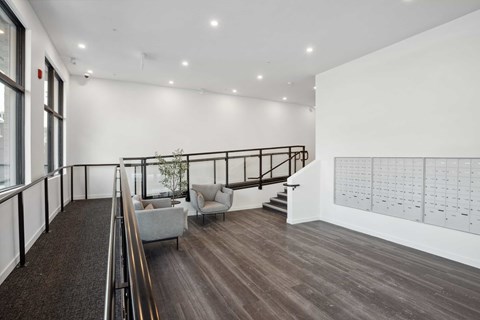A spacious interior with a staircase, chairs, and a calendar on the wall.