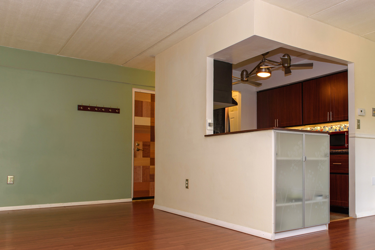 A kitchen area with a white counter and a refrigerator.