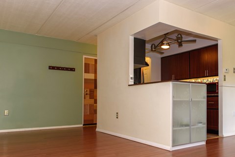 A kitchen area with a white counter and a refrigerator.