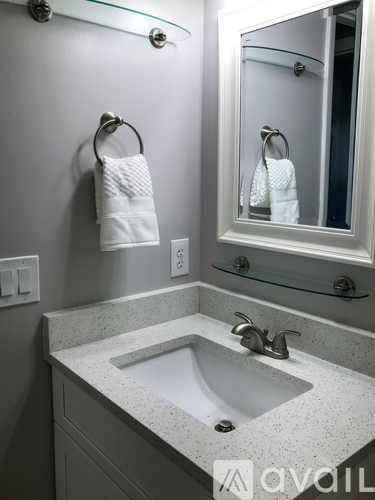 A white towel is hanging on a towel ring in a bathroom.