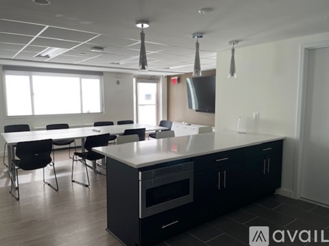 A modern kitchen with black cabinets and a white island.