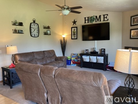 A living room with a brown couch and a black coffee table.