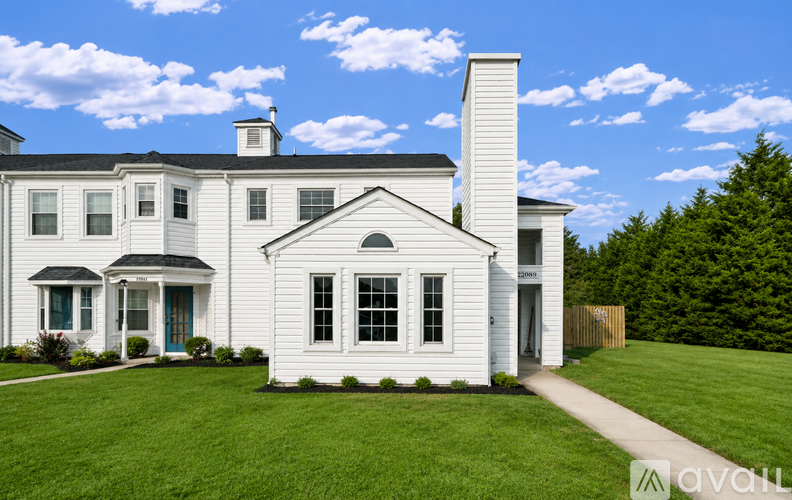 A white house with a blue door and a white chimney.