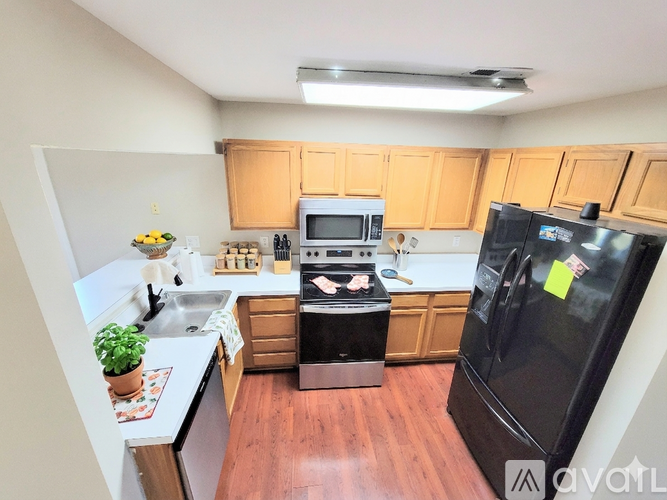 A kitchen with wooden cabinets and a black refrigerator.