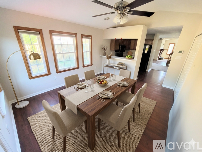 A dining room with a table set for a meal.