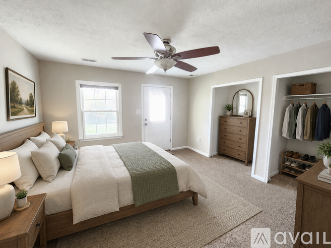 A bedroom with a large bed and a ceiling fan.