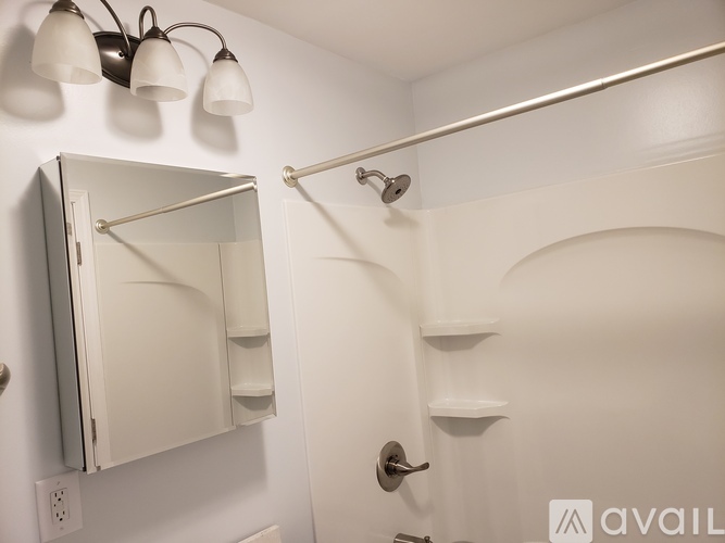 A white bathroom with a mirror and a shower.