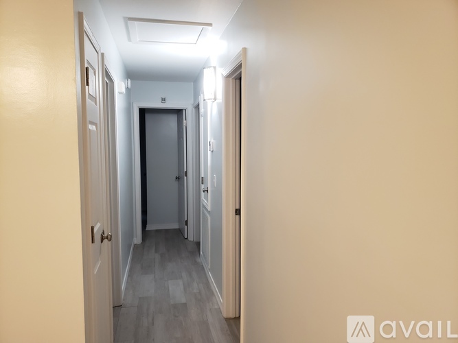 A long hallway with doors on both sides and a light on the ceiling.