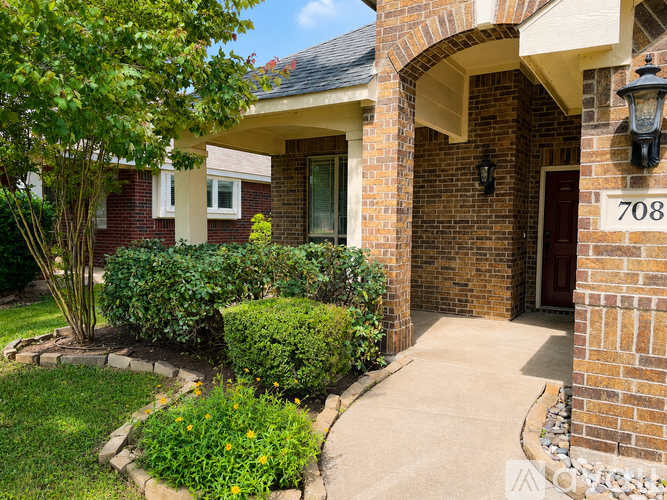 A house numbered 708 with a red door and a well-maintained garden.
