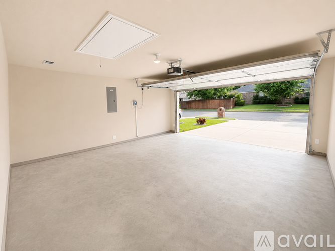 A spacious room with a slanted ceiling and a view of a backyard through a window.