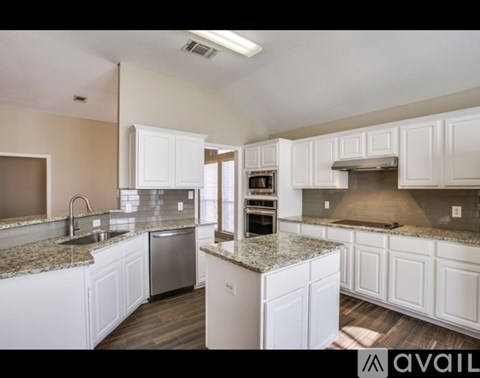 A kitchen with white cabinets and granite countertops is available.