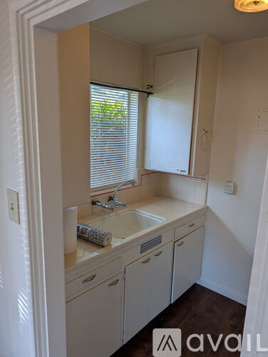 A bathroom with a sink, mirror, and cabinets.