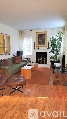A living room with a fireplace and a green couch.