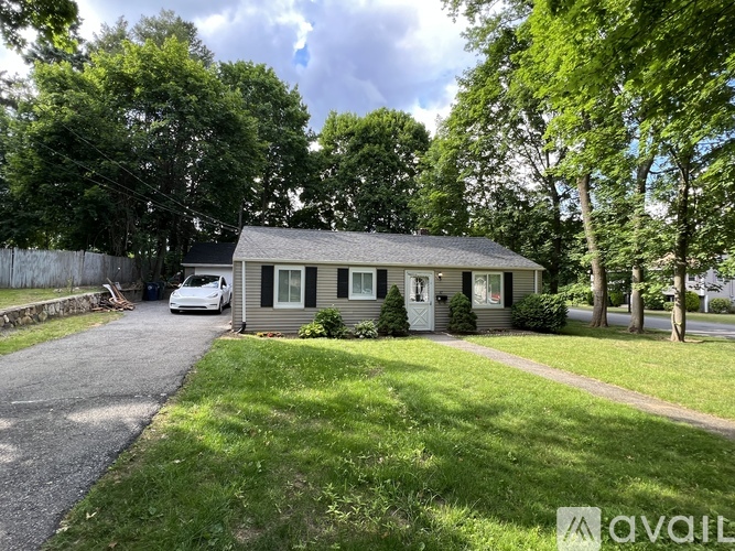 A house with a white car parked in front.