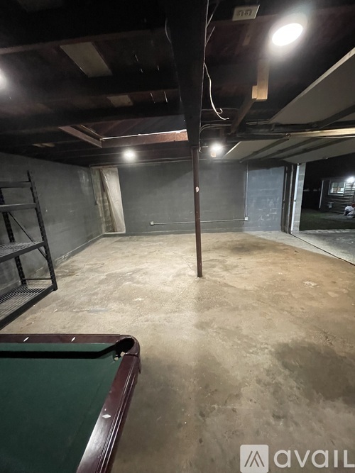 A room with a pool table and a shelf.