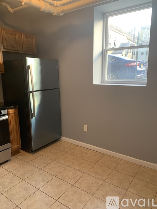 A kitchen with a fridge and a window.