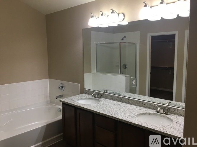 A bathroom with a marble countertop and a large mirror.